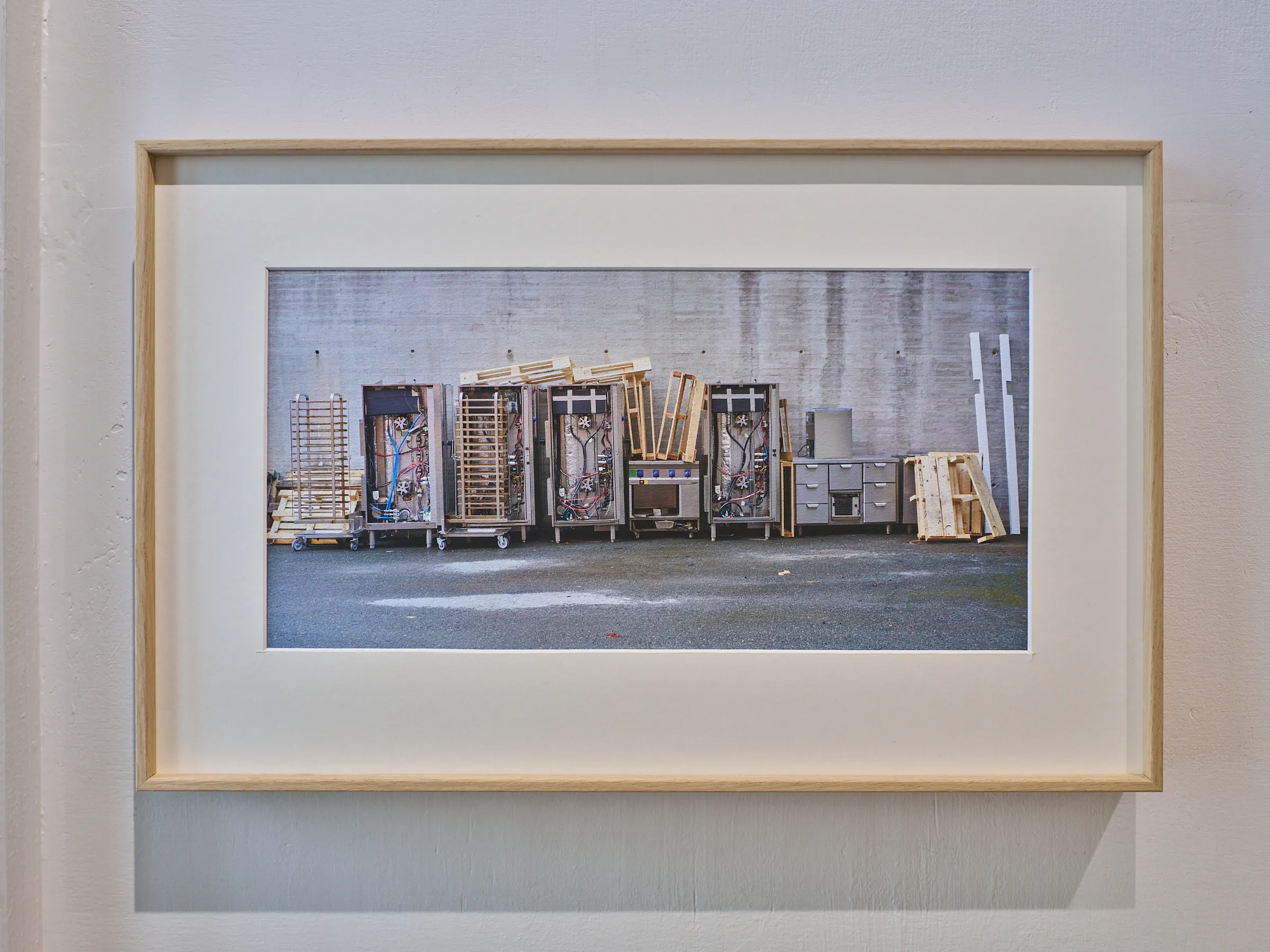 Breit gerahmte Fotografie einer Reihe von Industriewagen vor einer Betonwand