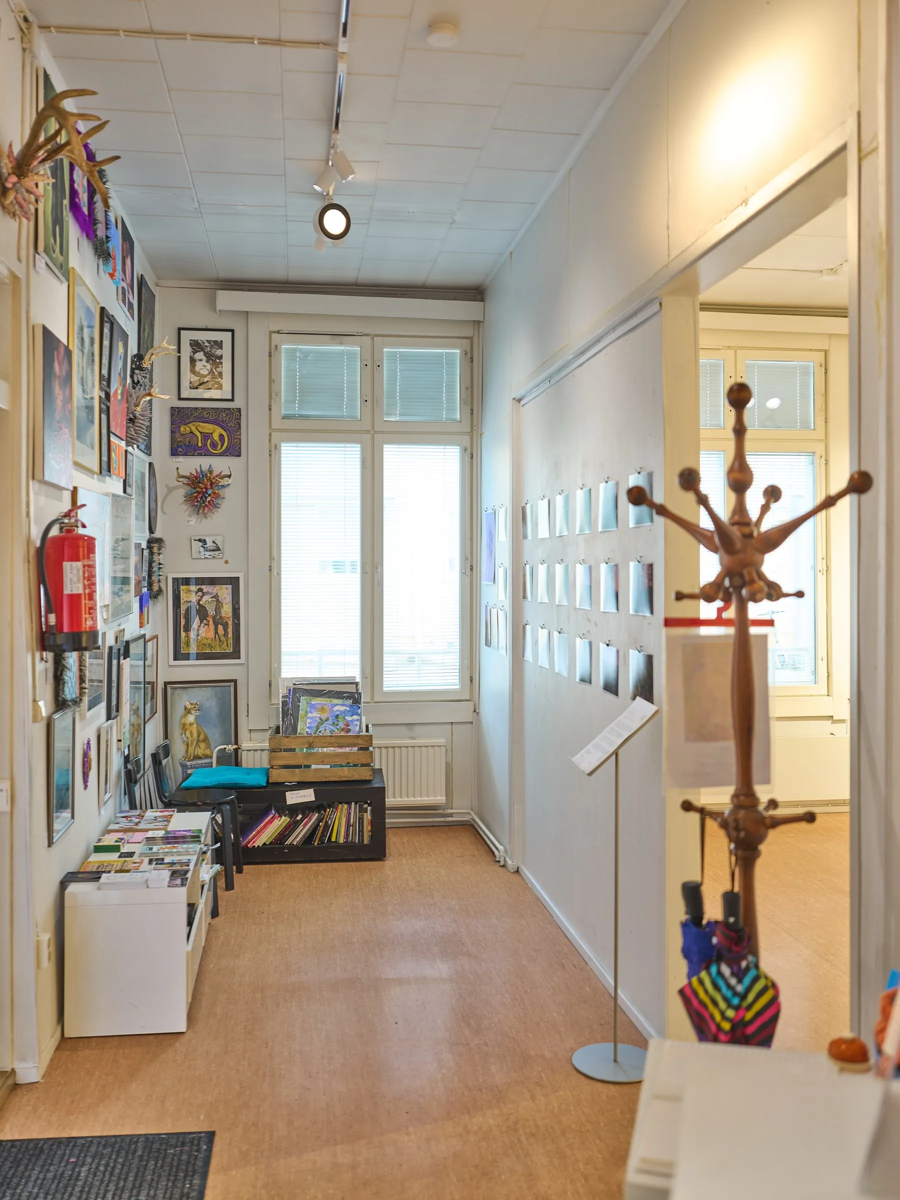 Flur der Galerie mit Holzboden und Bildern an den Wänden, Hochformat