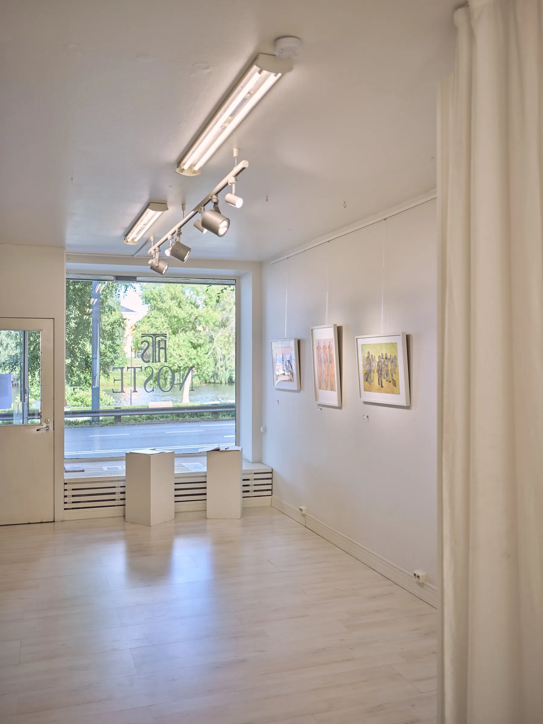 Galerieraum mit Spots an der Decke, Sockel vor dem Fenster, Vorhang rechts, Hochformat