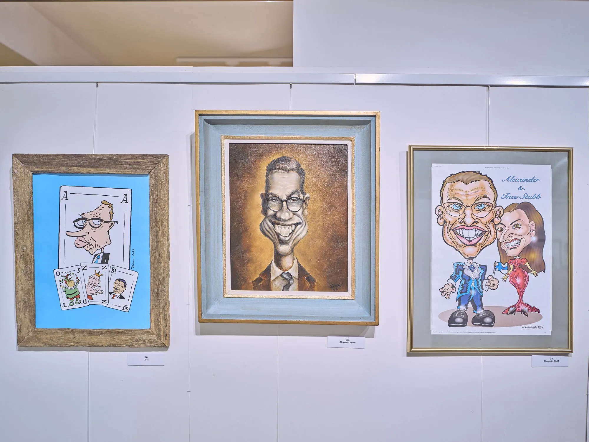 Drei sehr unterschiedliche Karikaturen von Alexander Stubb nebeneinander an einer Wand