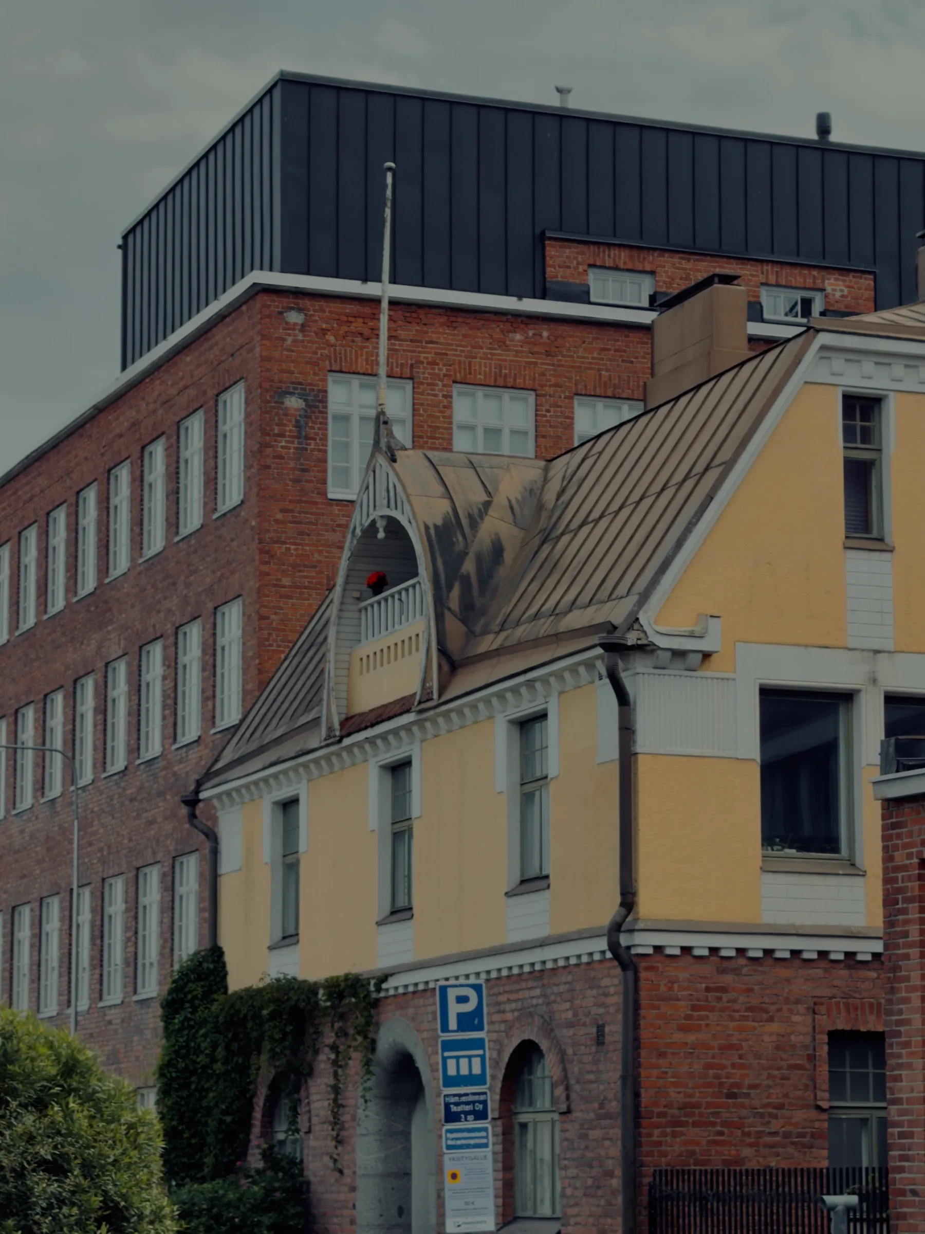 Der Jugendstilgiebel vor der roten Fabrik, dahinter der schwarze Kubus des Theaters