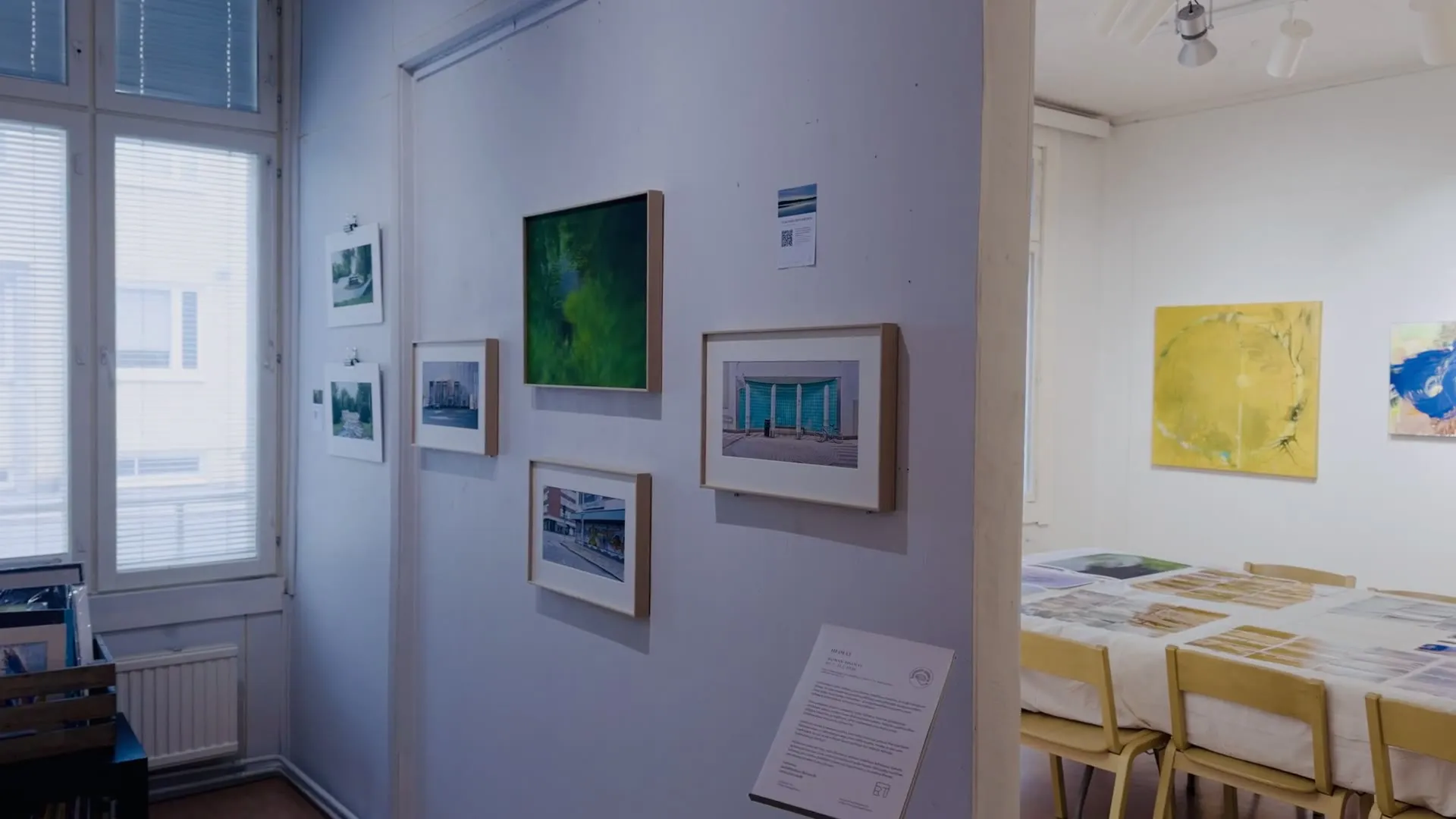 Video: langsamer Schwenk an der Ausstellungswand entlang, vorbei an gerahmten Fotografien und der Infotafel