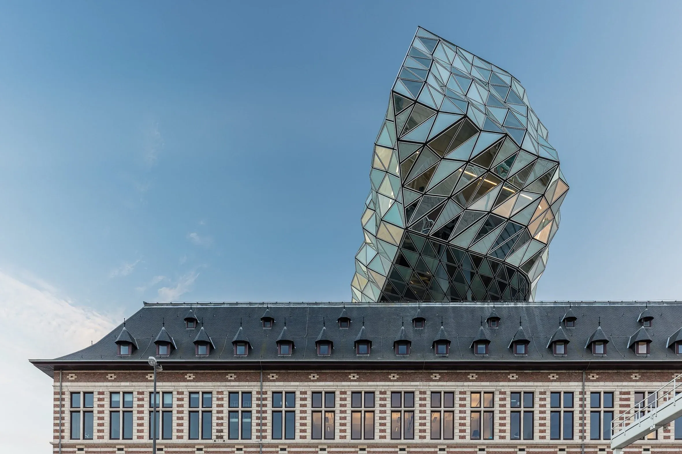 Hafenhaus Antwerpen, gläserner facettierter Aufbau von Zaha Hadid über dem Backsteinbau des alten Feuerwehrhauses, Tageslicht